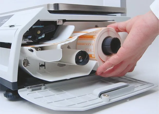 Abbildung zeigt den geöffneten Druckerbereich der Waage mit eingelegter Etikettenrolle